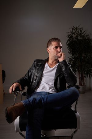 Thoughtful man on chair in barbershop