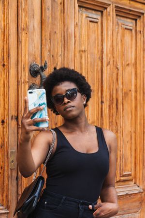 Young Black woman taking selfie on smartphone