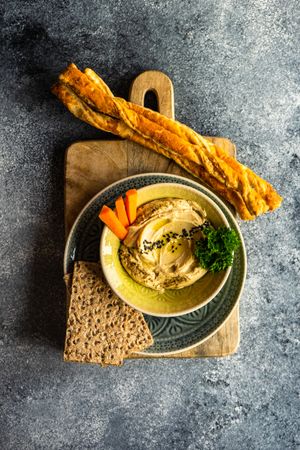 Top view of hummus dish in bowl on grey counter with space for text