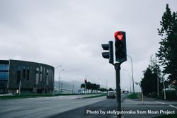 Red traffic light in heart shape against overcast sky, landscape 0PPeO0