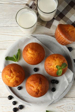 Composition with muffins and milk on wooden background