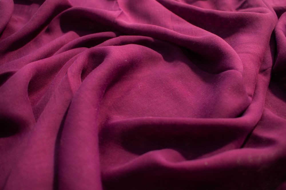 Soft purple fabric wavy spiral crumpled background abstract with copy space in the center