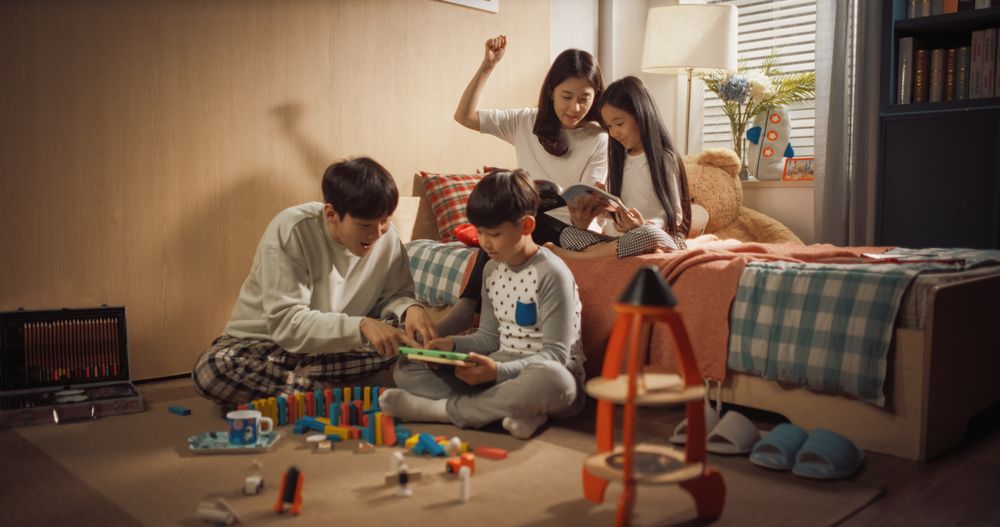 Asian Family Playing with Kids in Children's Bedroom.