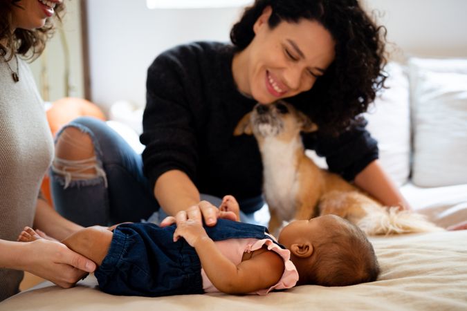 Two new mothers looking down at infant