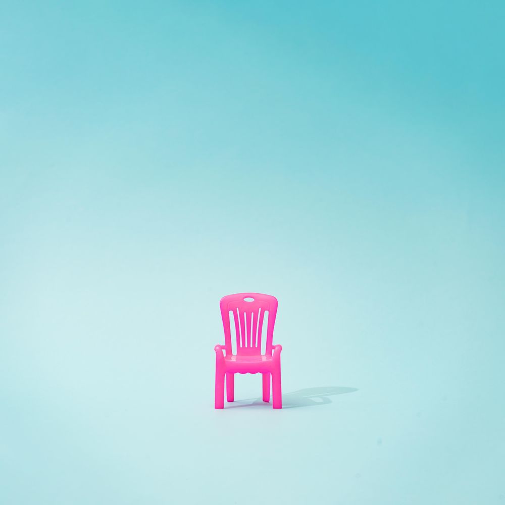 Pink outdoor chair on blue background