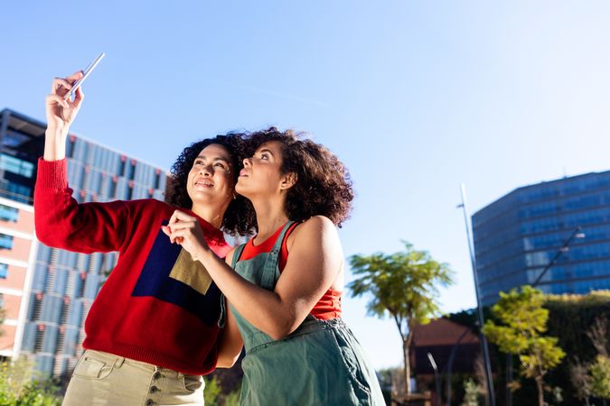 Female couple taking selfie on smartphone outside
