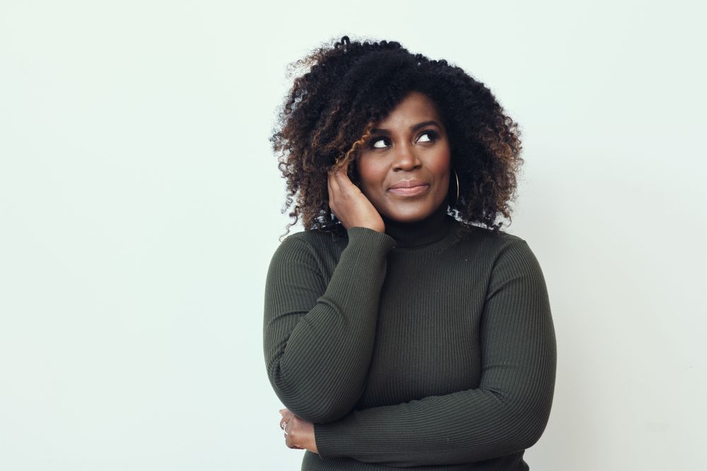 Black woman thinking about something with her hand to her cheek