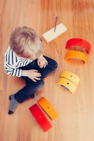 Boy playing with wooden construction pieces