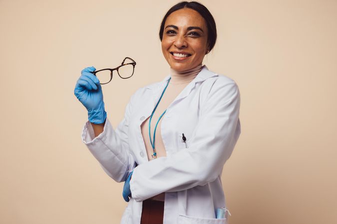 Positive woman doctor on brown background