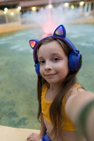 Schoolgirl resting at dusk by fountain