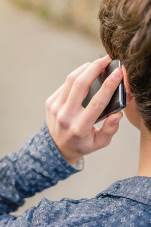 Hipster male talking with a smart phone outdoors