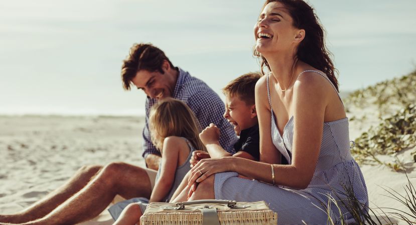 Family sitting on the beach and smiling