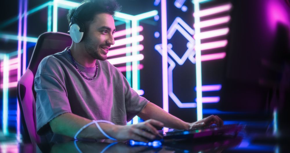 Excited Man Playing Video Games with Friends on a Computer, Surrounded by Cyberpunk Style Background.