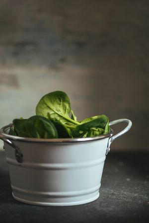 Fresh spinach on a rustic metal crockery bowl