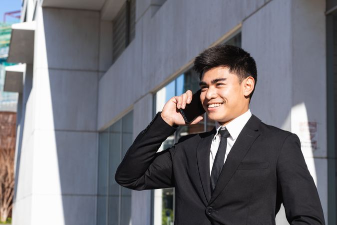 Smiling businessman speaking on smartphone in downtown