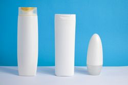 Multiple mockup cosmetic bottles in blue room