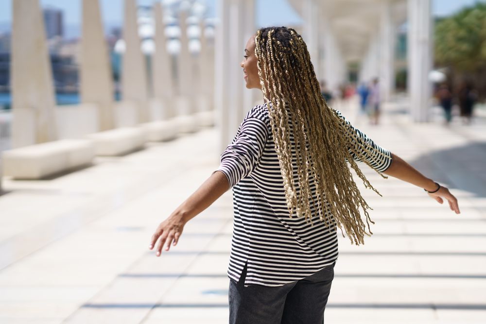 Woman spinning in bright outdoor area