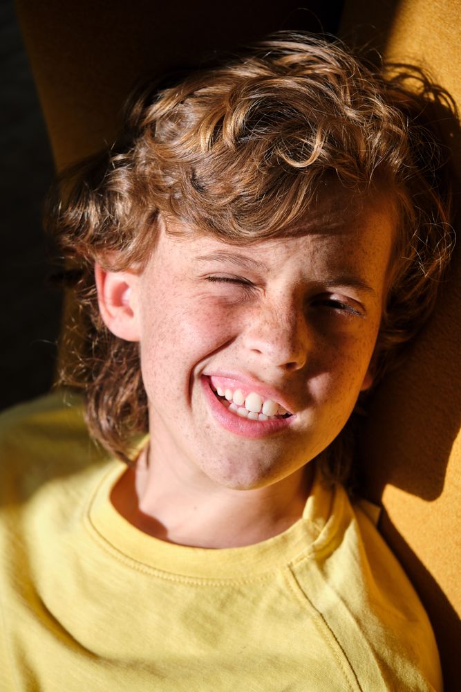 Smiling boy winking eye on sunny day