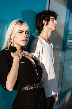 Charming sensual lady and calm guy against blue glossy wall