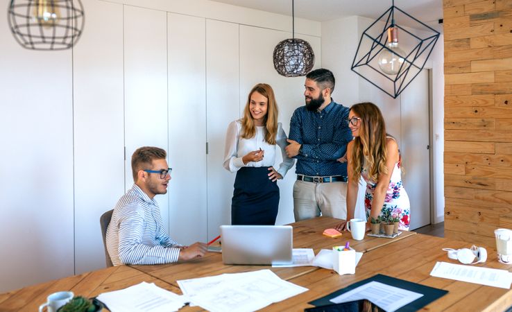 Business people in a meeting standing checking a project on the laptop