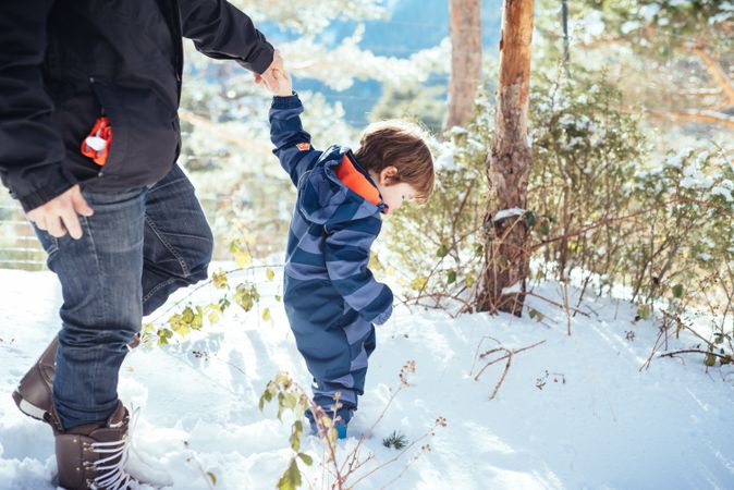 Man with kid walking in snowy yard