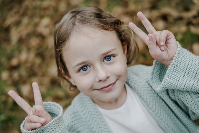 Smiling girl between meadow with dry leaves