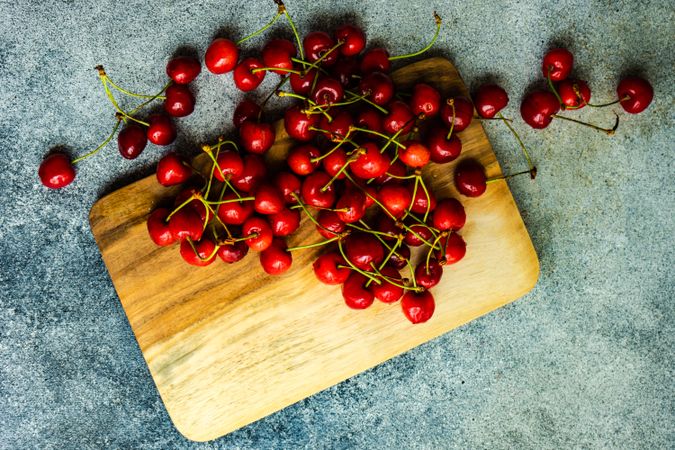 Top view of summer cherries scattered on wooden board