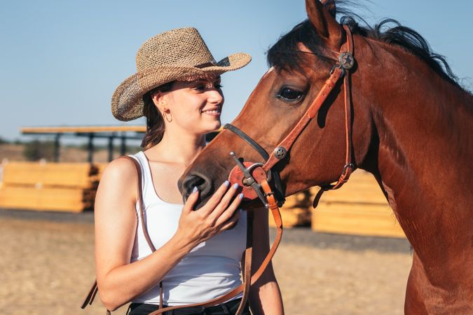 Woman saddling his horse in a riding center