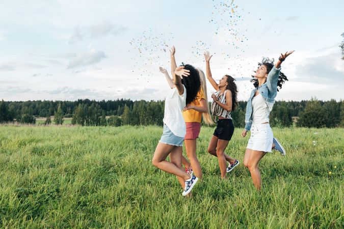 Group of women throwing confetti in a field