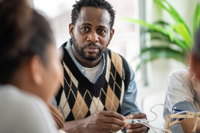 Black male teacher listening to student’s questions in class