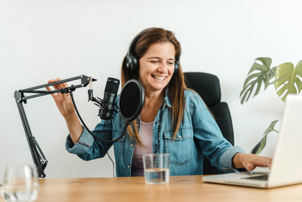 Woman using laptop and recording podcast