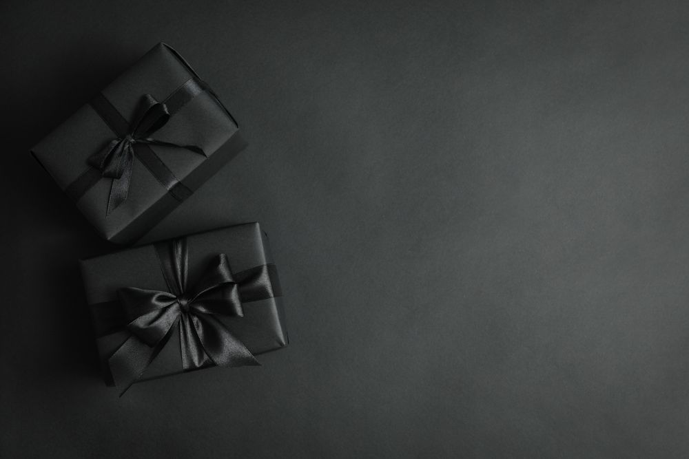 Gift boxes with dark bows on dark background