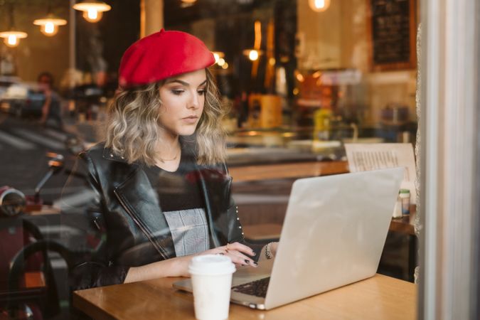Dreamy woman using laptop in cafe