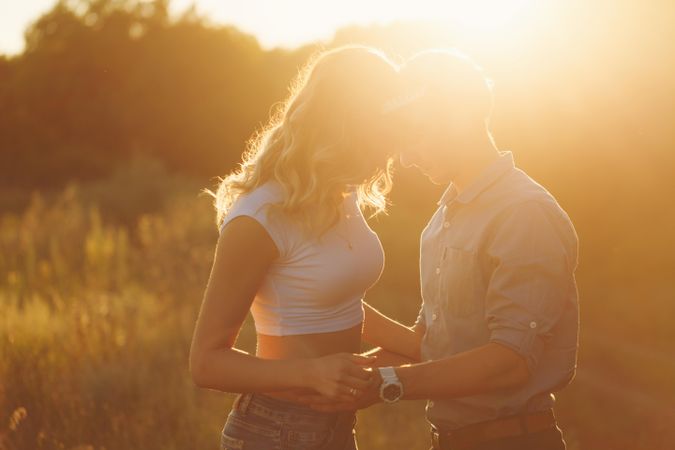 Backlit shot of couple embracing at sunset