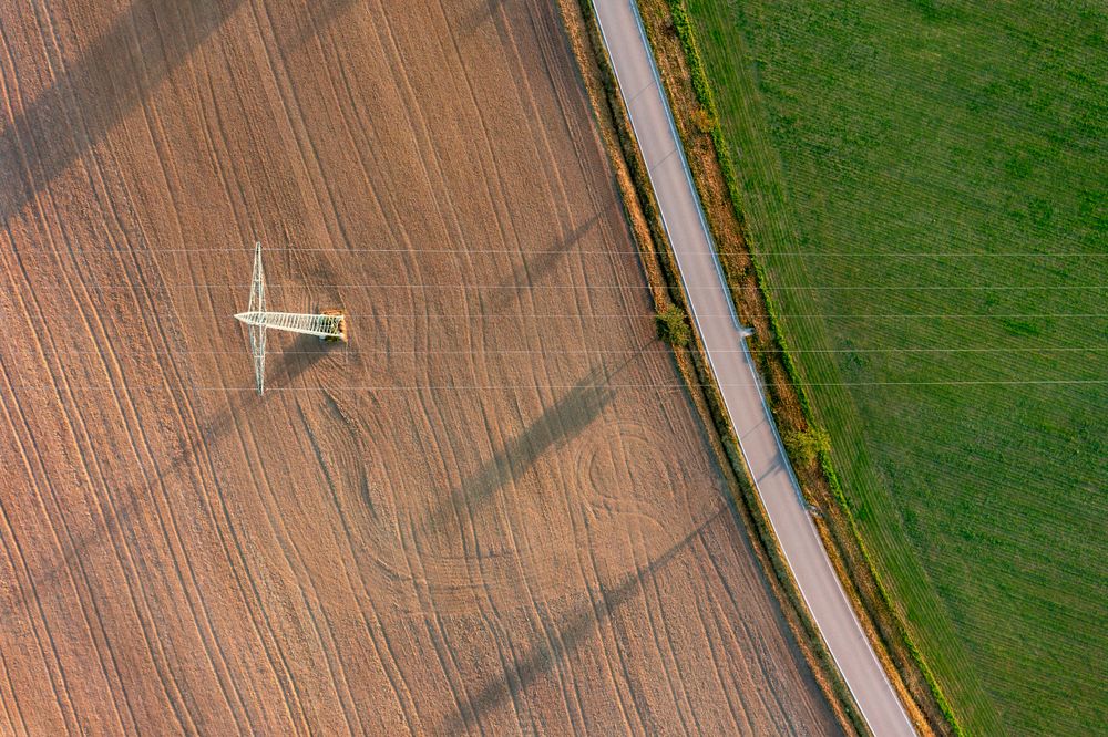 Electricity pylon aerial view at sunrise in a german village