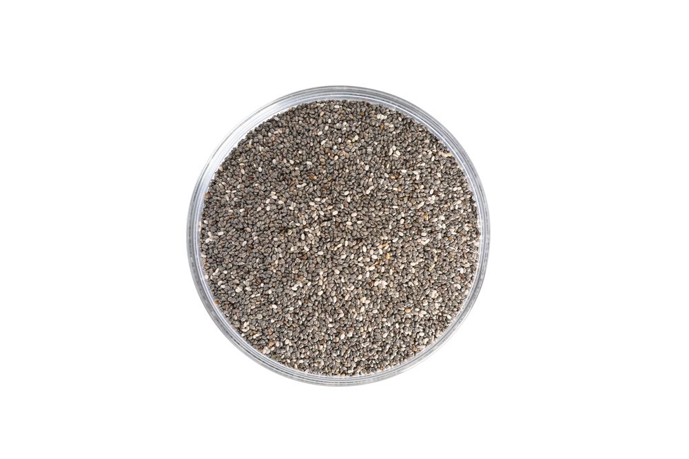 Chia seeds in glass bowl isolated on neutral background