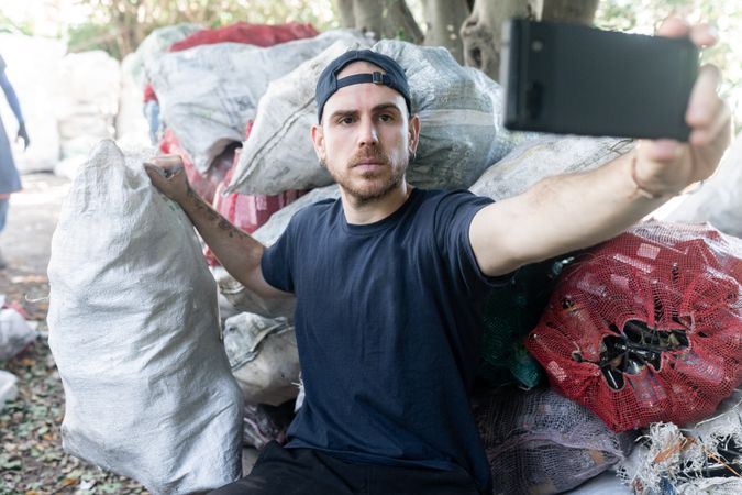 Young Man Taking Selfie with Recycled Materials