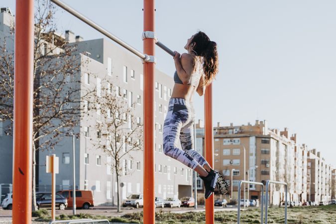 Woman training on parallel bars on street