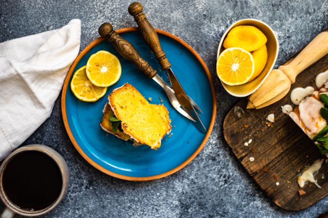 Tasty lemon cake with fresh mint served on blue plate with coffee