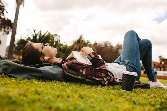 Young woman relaxing at a park on college campus