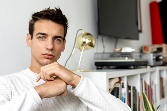 Confident young man lounging at home on the sofa looking at the camera