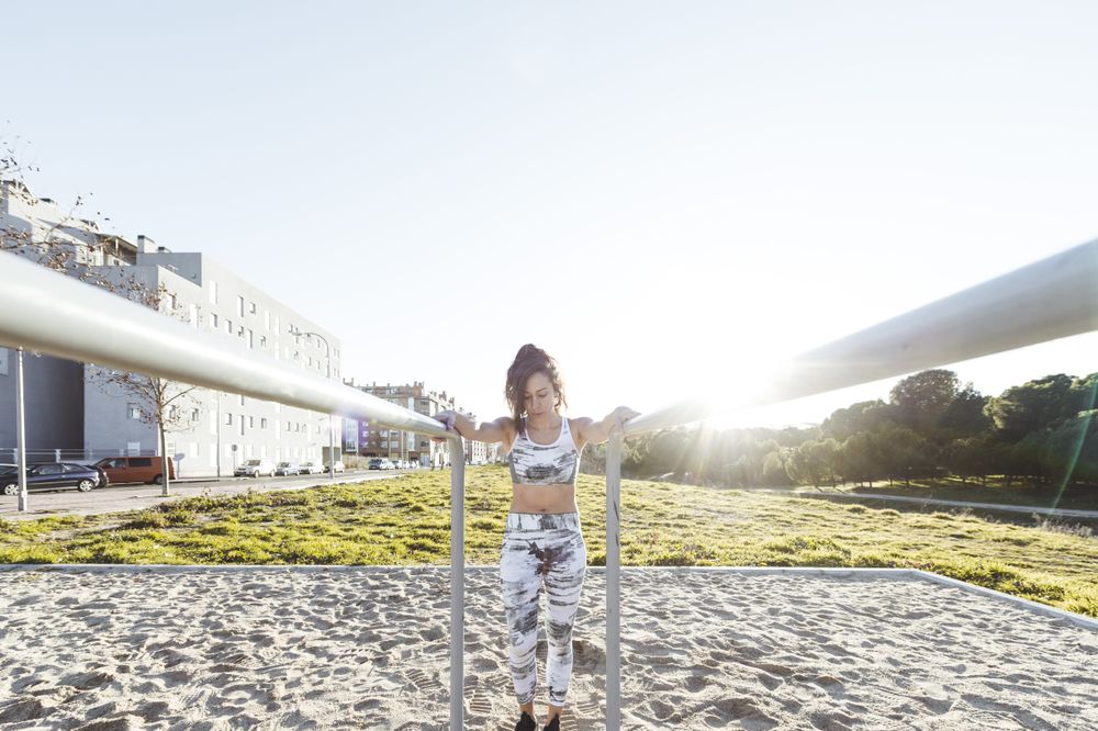 Young woman training on parallel bars