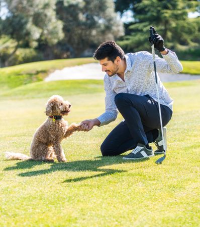 Man playing with a dog in golf course