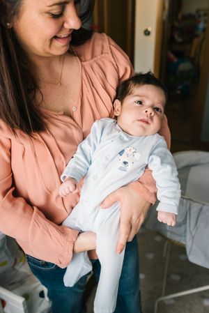 Mom holding newborn on hands at home