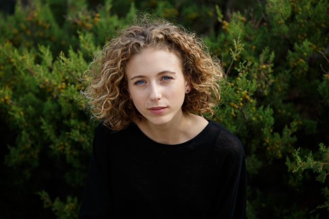 Young woman near dry twigs of bushes