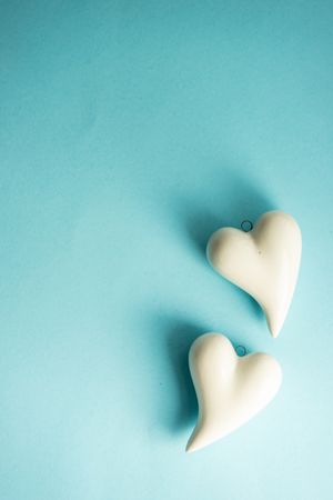 Ceramic heart ornaments on pastel blue background