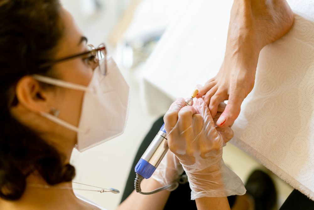 Nail varnish being removed from female feet in professional spa