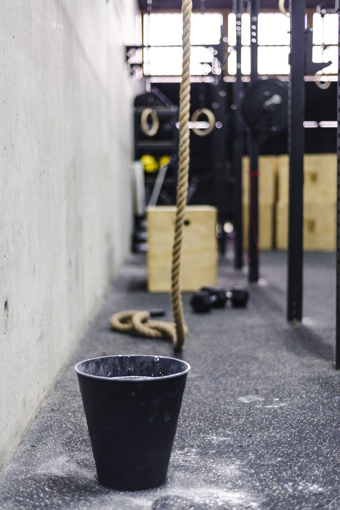 Rope near bucket of chalk in gym