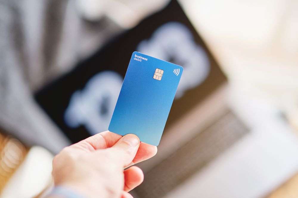 Business debit card above laptop