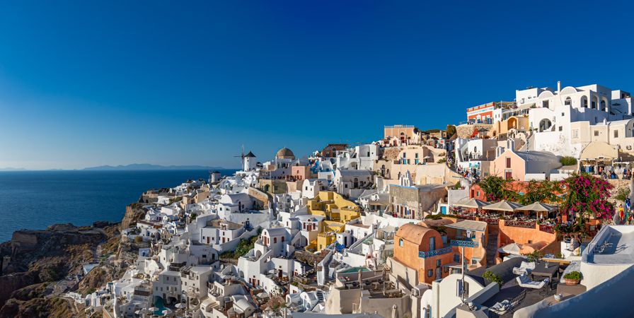 Wide shot of buildings overlooking a cliff in Greece